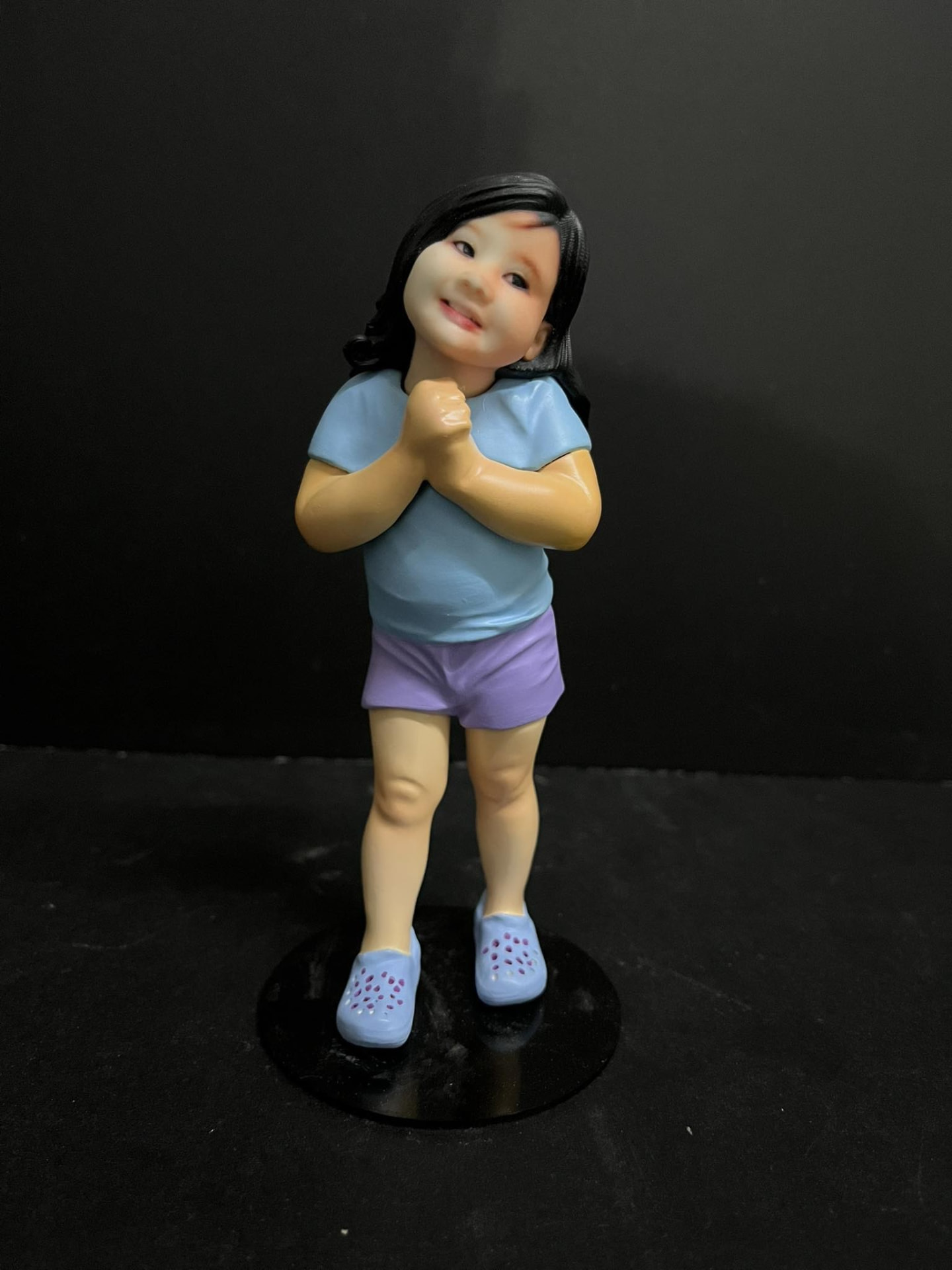 Full-color 3D printed figurine of a young girl in a blue shirt and purple shorts