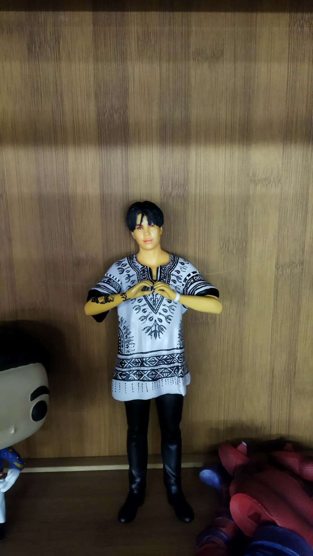Full-color 3D printed figurine of a person in a patterned white tunic making a heart sign